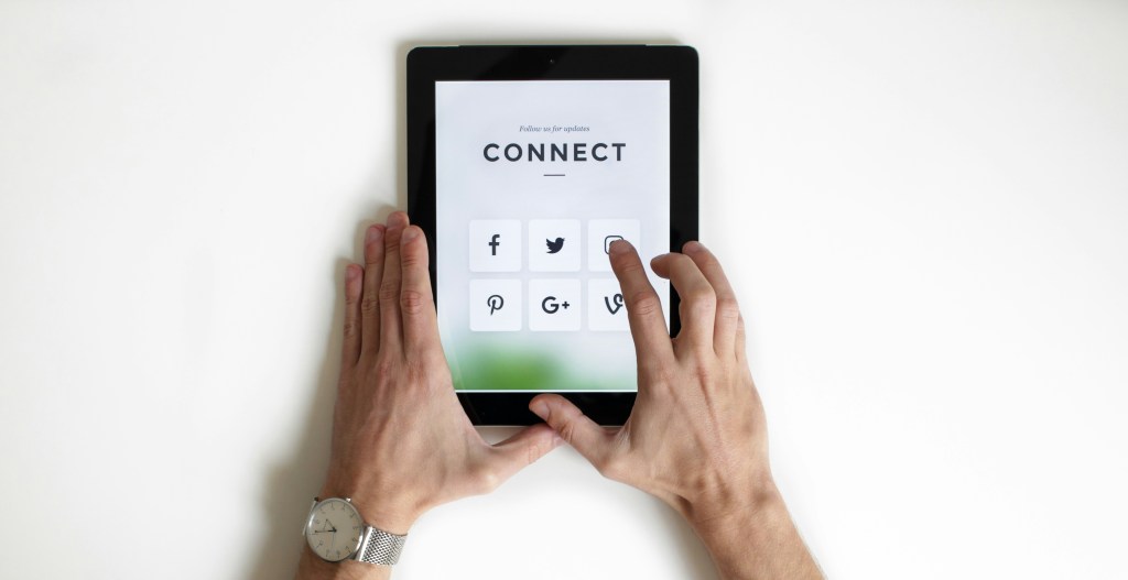 Man holding tablet with social media apps on display